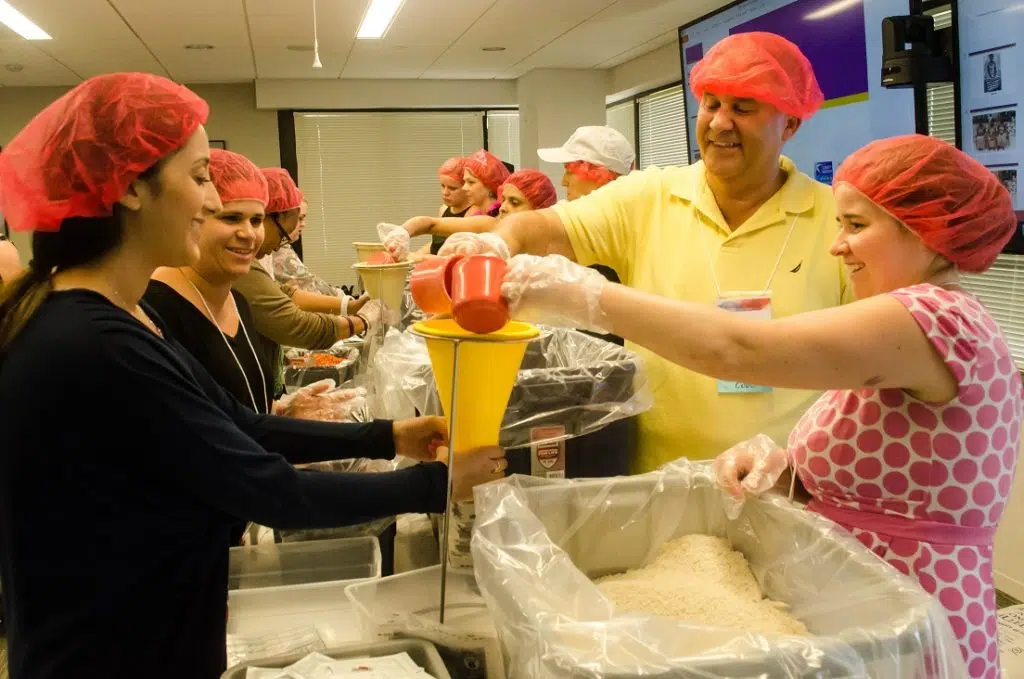 Global Impact employees participate in a food packing event.