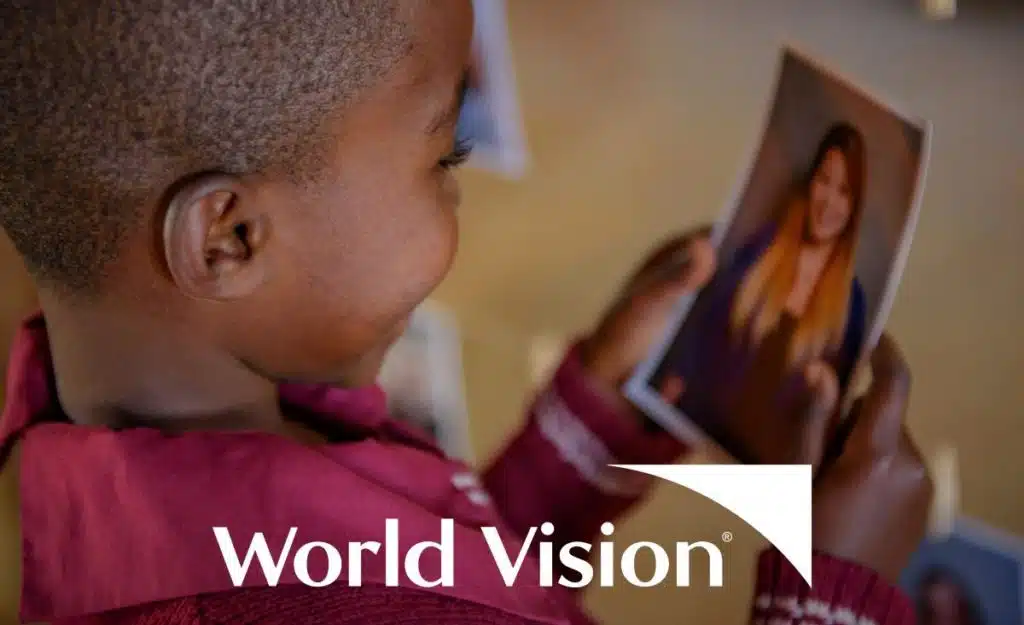 World Vision logo over a boy looking at a photo