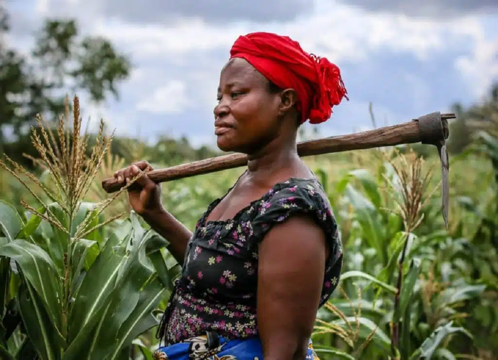 Women holding farming equipment in a field
