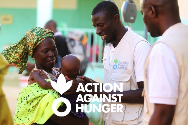 Action Against Hunger staff help woman with baby.