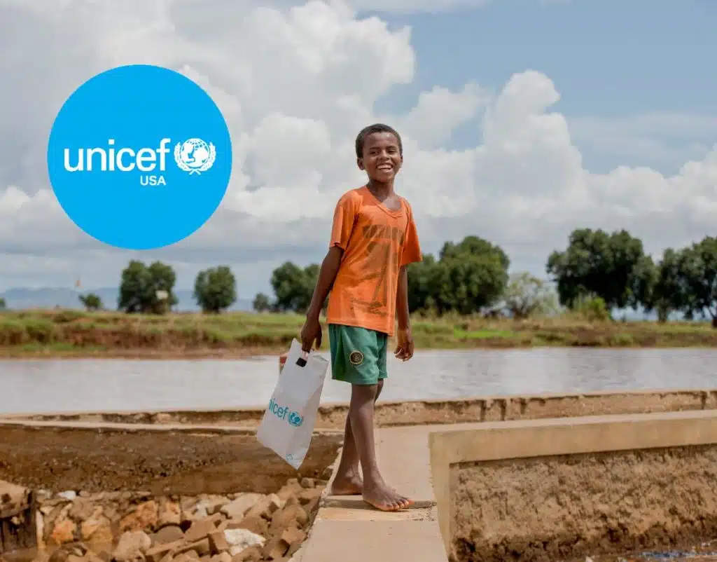 UNICEF USA logo over photo of a boy holding a white bag