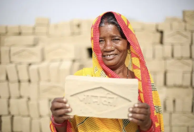 Photo of woman holding up a brick