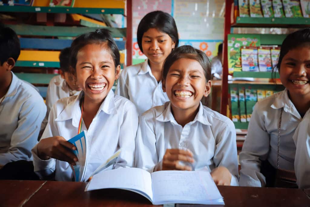 Girls smiling with books in front of them
