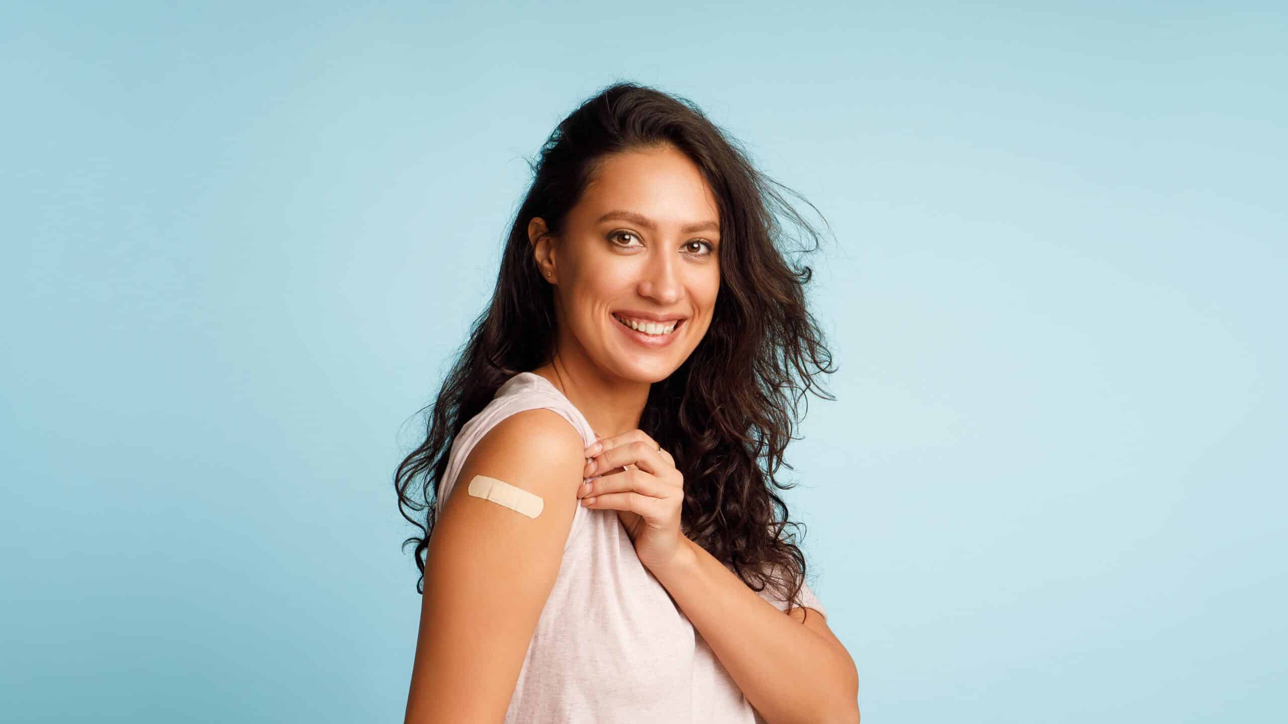Woman smiling with bandaid on arm