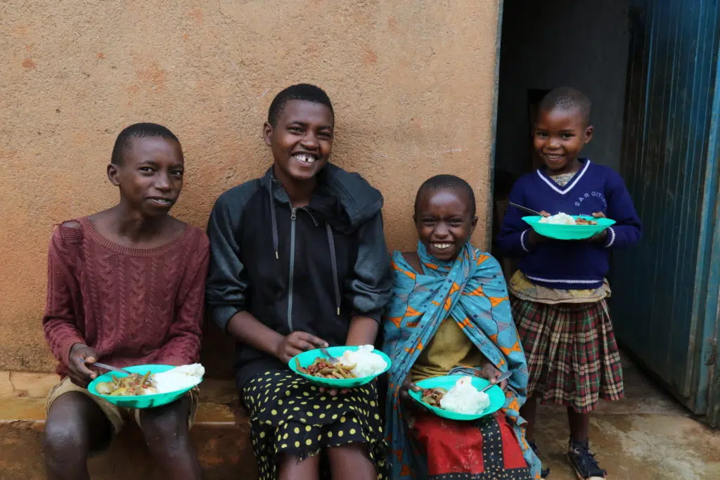 Children smiling with plates of food