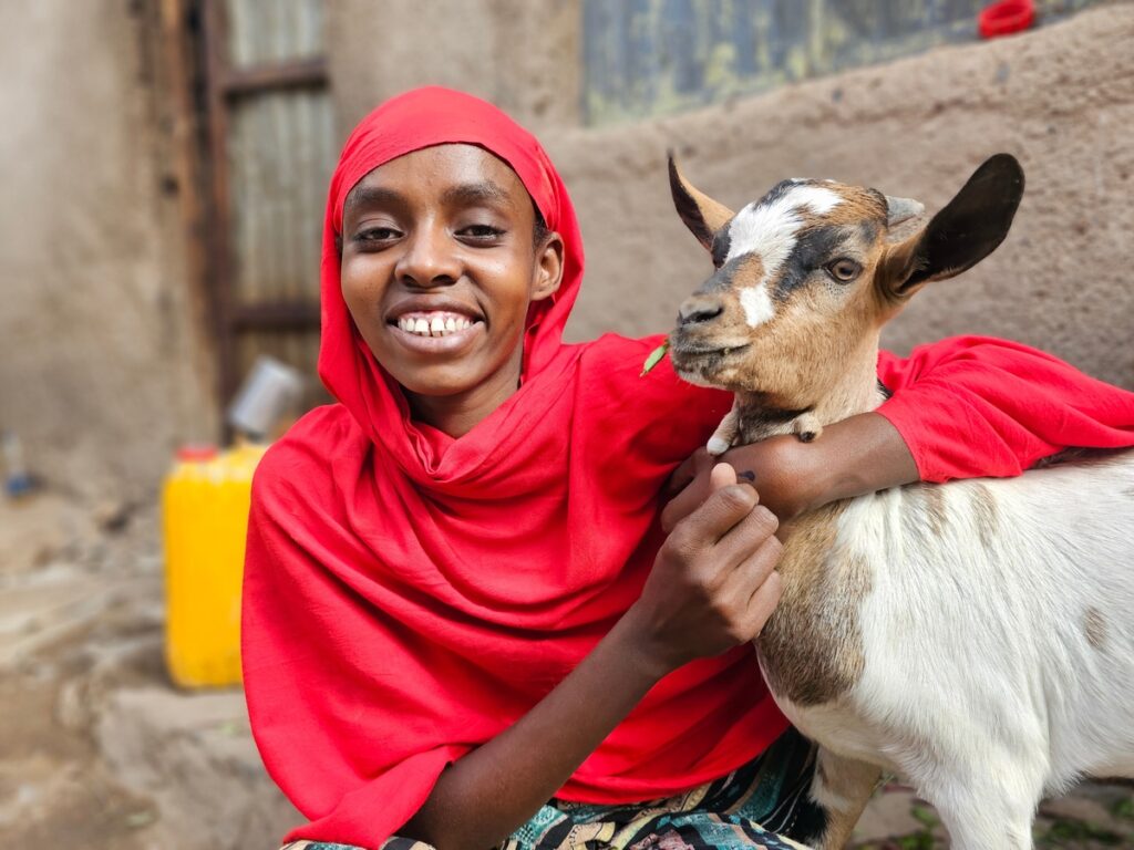 Seniya, 22, she is a member of a CARE Youth VSLA group. With the money from CARE (cash livlihood transfer) with the support from Beiersdorf she was able to buy herself some goats and chickens which she raises and sells. I have fourteen chickens, but only seven of them lay eggs, because I cannot afford to feed them properly. Sometimes I go to hotels and ask them for the guests leftovers to save money on the feed for my animals, explains the 22-year-old. She sells one egg for 10 Ethiopian Birr (around 17 cents). Some of her income she saves for a girls savings group which CARE, with the support of Beiersdorf, has established to support girls businesses, give trainings, and spread awareness on different topics such as early marriage. Seniya is one of the money box key holders in her group of thirty young women aged between 18 and 24, and todays session is being held in the courtyard of her home. Three plates in red, green, and blue are placed in front of her. One for todays savings, one for the social fund, which they use to support others during times of personal crisis, and one for the penalty payment if someone was late to pay back their loan. Today the guided discussion topic was on early marriage. When asked who was married before the age of 18, half the girls raise their hands. When asked who had an early marriage proposal, but was able to deny it, the hands of the other half goes up  including Seniyas. Seniya had her first marriage proposal when she was 16, but she and her mother refused. I am the oldest of nine siblings. I learnt from my mother and friends who married early and had children with difficult deliveries with a very hard life. That scared me. So, I said no. I did not want that for myself, she explains. Seniyas mother Nujuma, 35, was married when she was 15 and had Seniya at 16, when she herself was still a child. Being a mother or a wife is not just about having children. I want to be able to be a parent to my child and not have to grow up together with my own children. This young you do not even know how to breastfeed properly and giving birth is so dangerous. I also want to protect my younger sisters from marrying early, says Seniya. "When I gave birth to Seniya, my body could not handle it. It was very difficult for me to carry. I was in labor for two days and I did not have enough breastmilk for her, her mother Nujuma says. I only have a little income. I sell papaya on the street. Sometimes, when I am very desperate, I go knocking from door to door to try and find someone who will buy something. It is very difficult work. The marks on my face are because I had a lifetime of working in the hot sun, Nujuma describes. I work hard, but it is not enough for all of us. When we buy clothes, it is on loan. And we also cannot afford enough food for everyone. Seniya and I often skip meals, so the other children can eat first, describes Nujuma and sighs heavily, shrinking a little in her posture. Then Seniya comes back out of the kitchen to fetch a jerrican of water and places a broom in the hand of one of her siblings, and Nujuma straightens again. But with her business we are surviving, and she has so many plans for the future. She is our strength.