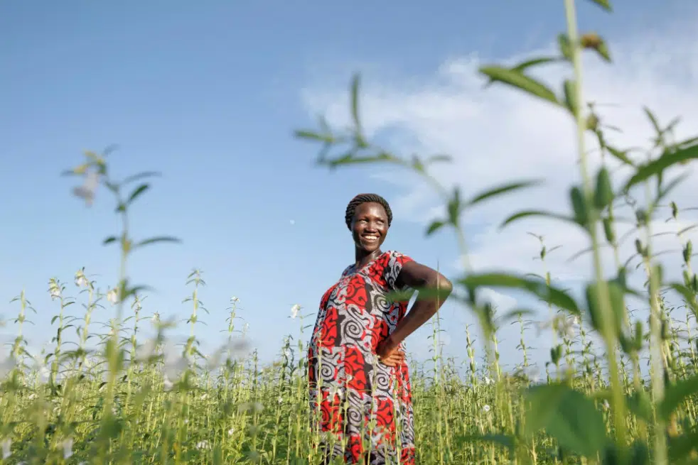 Rose Kujang, a refugee from South Sudan, stands in the sesame fields she shares with her farmer’s group.