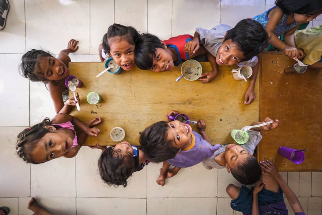 Children at a table looking up at the camera
