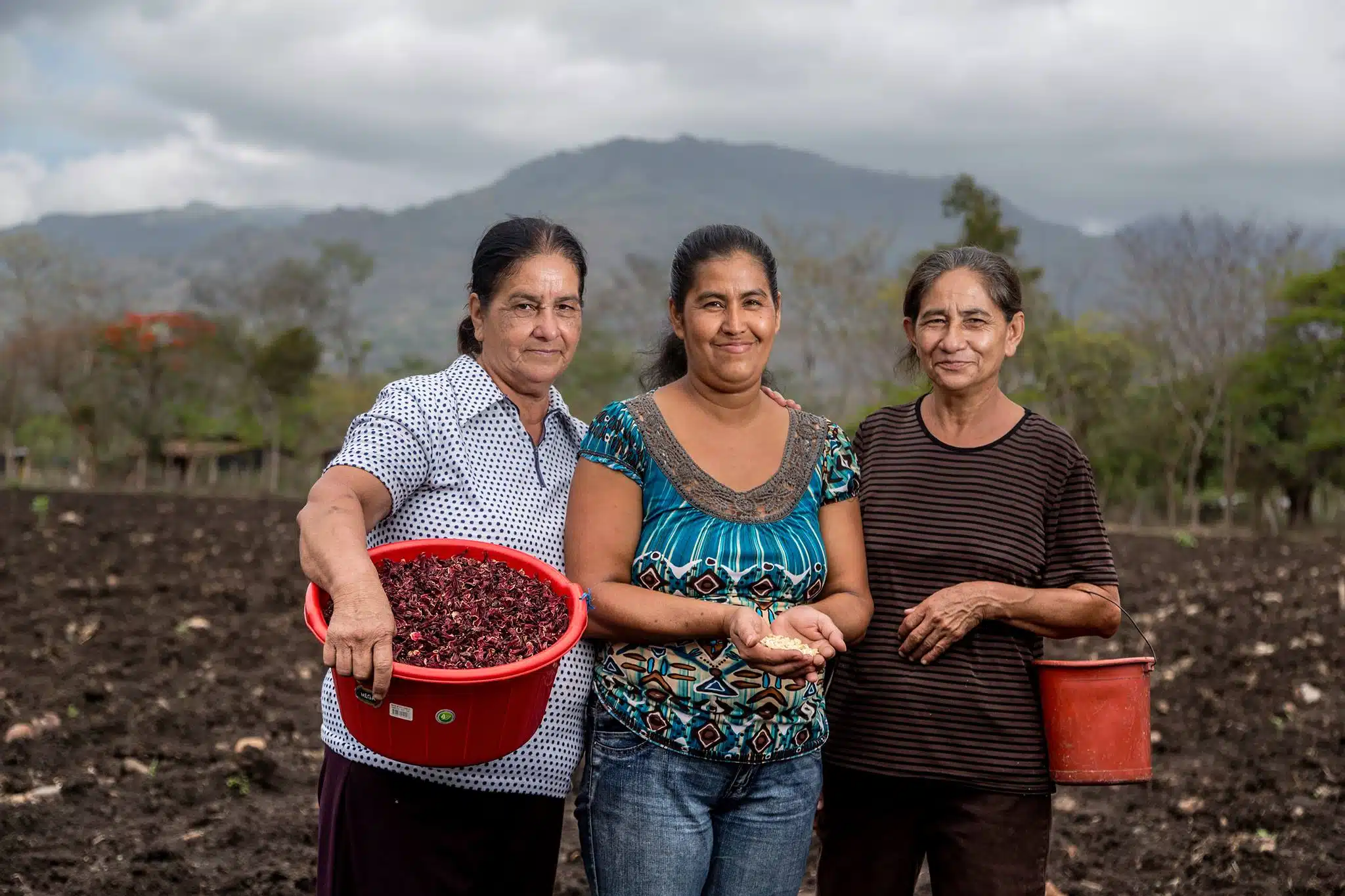 Three women posing in front in a field