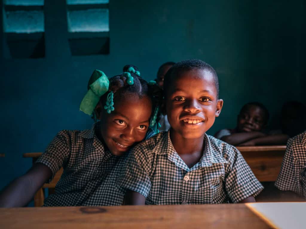 Two students smiling in a classroom.