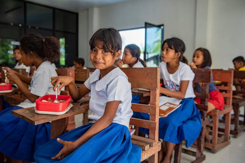 Students sit at their desks with their lunches