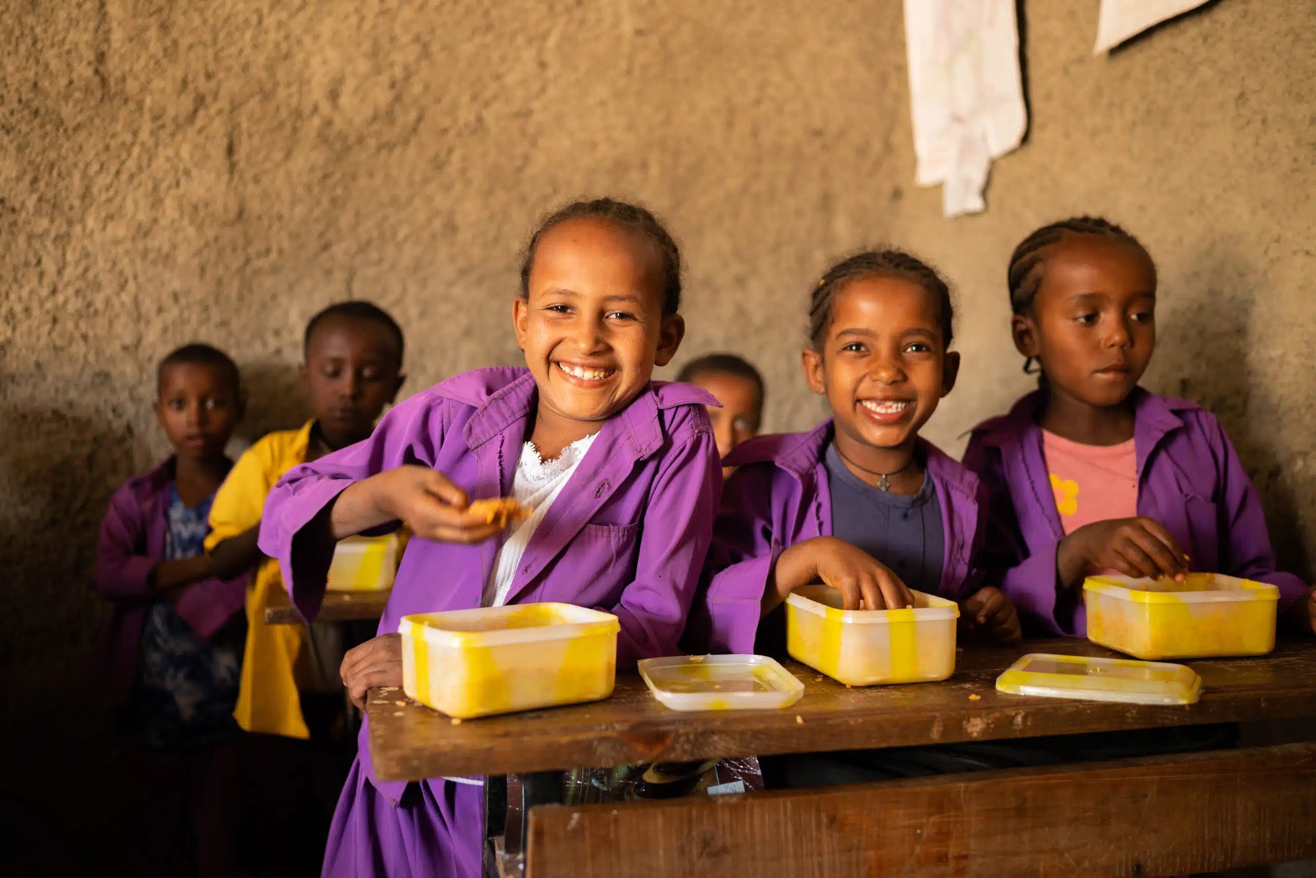 Children smiling at school with their lunchboxes