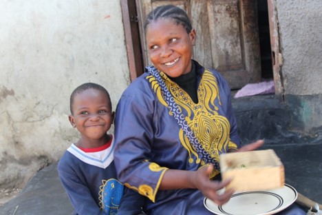 Mother in Zambia laughs with her young child.