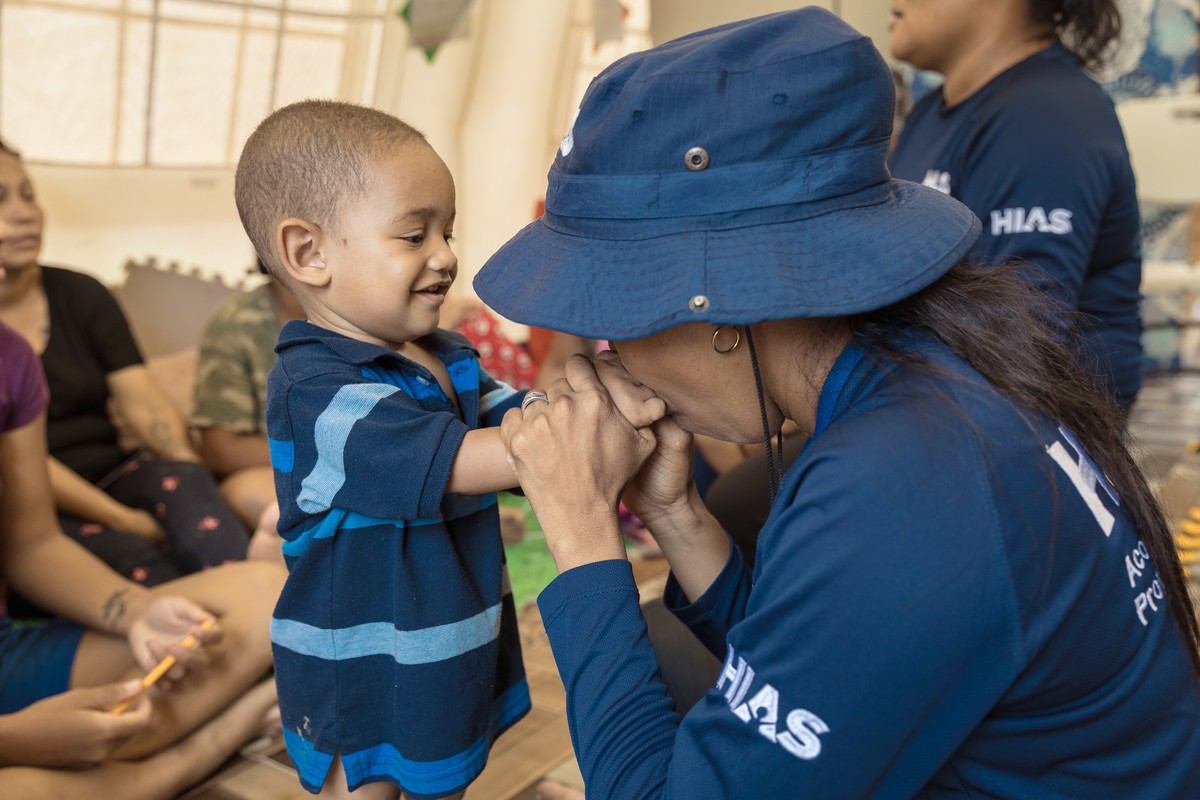 Dilsa Sanchez (HIAS) plays with a migrant child during a group conversation inside the Hias support tent in the Migration reception center of Lajas Blancas, Darien province, Panama. July 31, 2023.