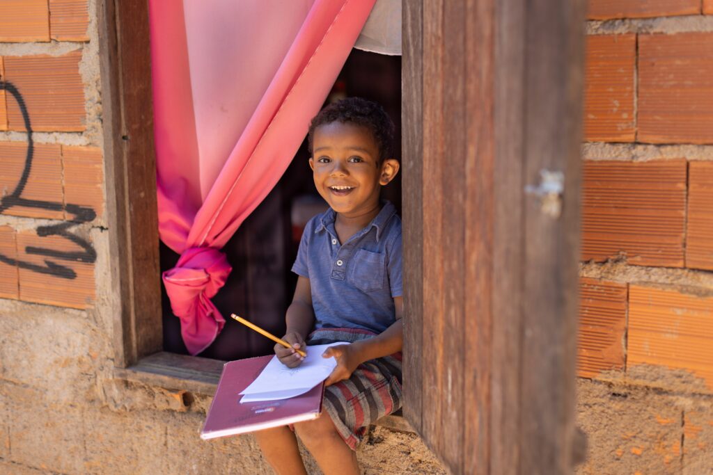 A boy with pencil and paper smiling