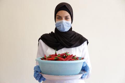 Woman holding a basket of peppers