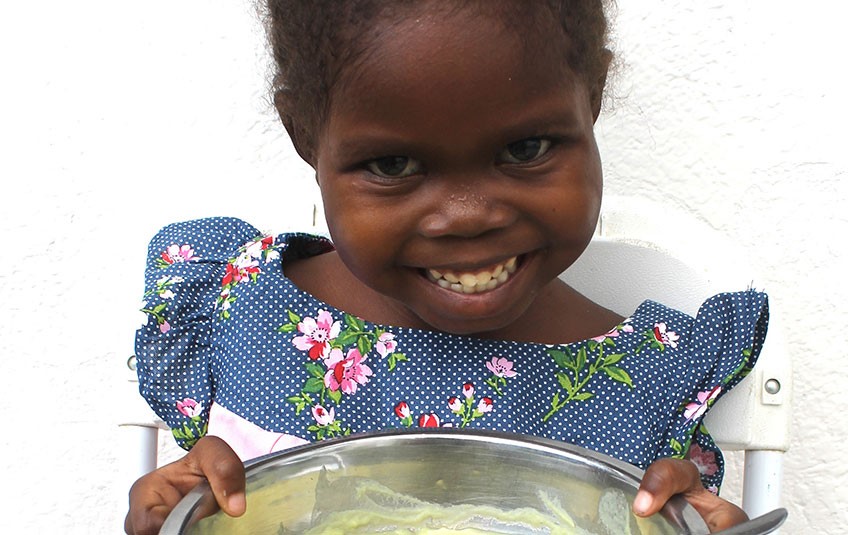 Esther smiling with a bowl of food
