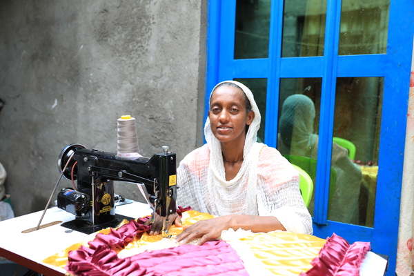 Hiwot is sewing bed sheets and garments, which she sells in the local market and generates income from to support her children.