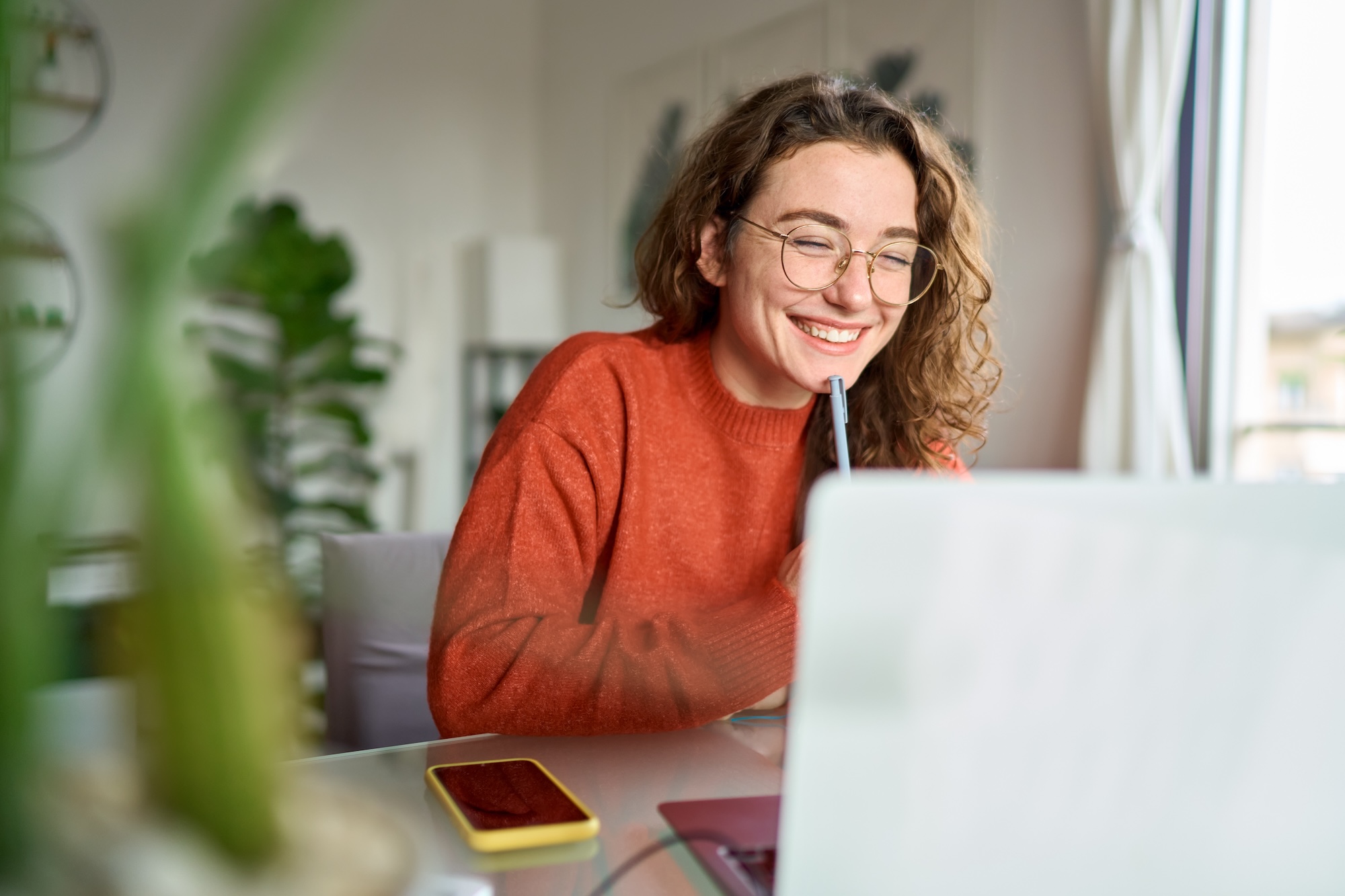 Person smiling while looking at laptop screen